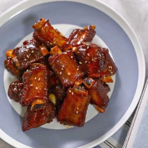 糖醋排骨 (táng cù pái gǔ) : Côtes de porc marinées et caramélisées dans une sauce ai